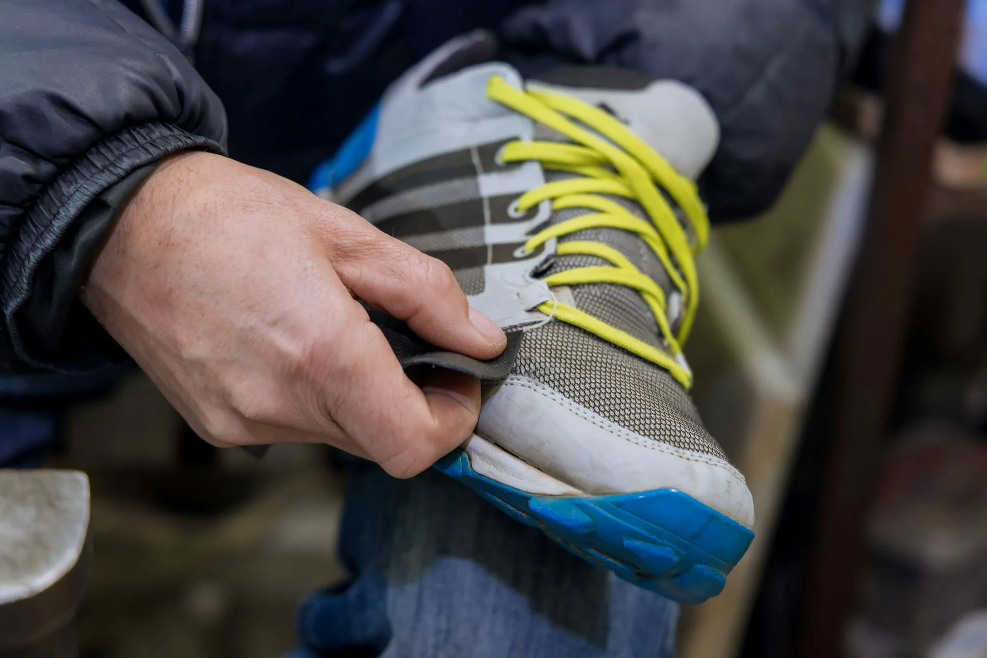 A master shoe repairer takes care of shoes in his workshop for the repair of shoes